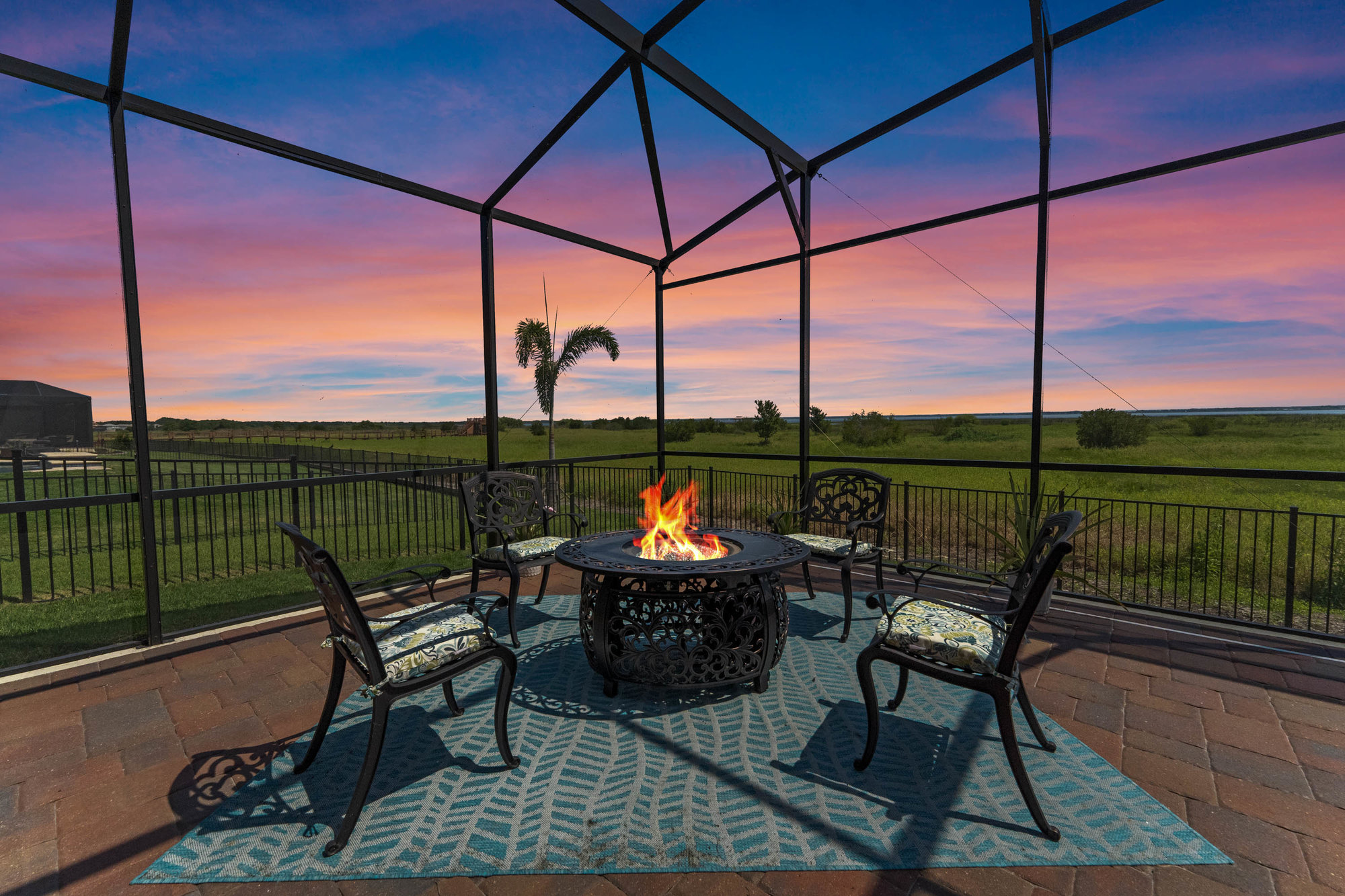 fire pit lit at night with metal chairs around